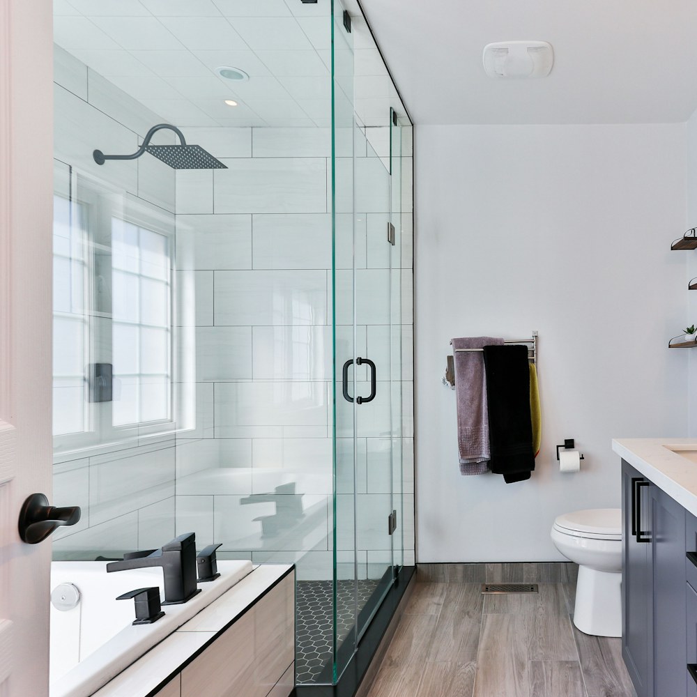 Baño remodelado con regadera de vidrio